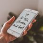 holding an iphone with meditation and self care application